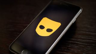 The "Grindr" app logo is seen on a mobile phone screen